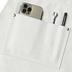 Close-up detail view of a heavy white canvas work apron pocket with practical design.