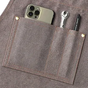 Detailed shot of heavy-duty canvas work apron pocket with tool storage and sturdy rivets.