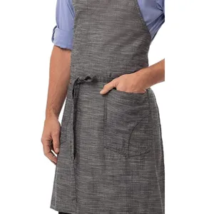 Detailed view of gray cotton linen work apron with front pockets and waist tie for cooking.