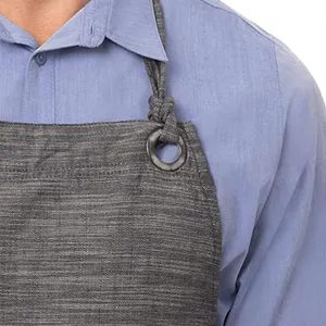 Close-up detail of dark grey cotton linen apron strap, metal ring buckle, workwear.