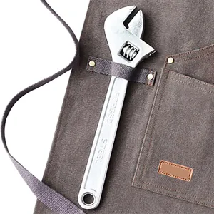 Heavy duty canvas work apron with tool pockets and adjustable straps for BBQ and kitchen use