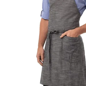 Detailed view of a grey cotton linen apron featuring front utility pocket and waist ties.