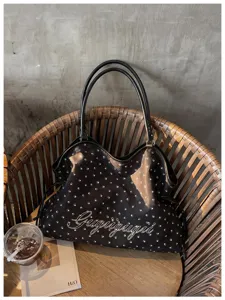 Vue détaillée du sac cabas noir avec des empreintes, design élégant et chic.