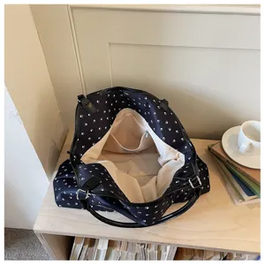 Vue détaillée du sac cabas en toile noire avec motif de pattes et grand espace intérieur.