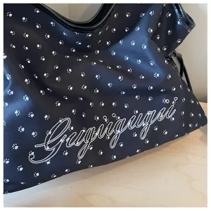 Sac cabas noir en toile avec de jolis motifs d'empreintes de pattes et broderie élégante.