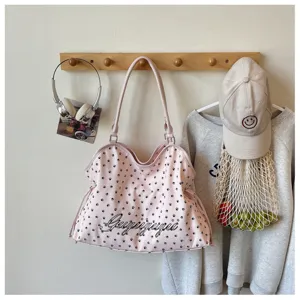 Détail du sac cabas rose présentant un joli motif d'empreinte de patte et lettres stylées.