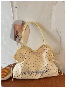 Gros plan du sac cabas jaune avec imprimé pattes et détails d'écriture stylés dans un beau décor.