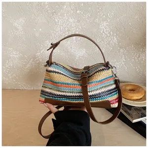 Bolso bandolera de paja tejida con rayas de colores y ribete de cuero para vacaciones de verano.