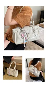Detailed view of cream vintage faux leather shoulder bag with metallic buckle and charms.