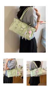 Detailed view of the stylish light green patent leather shoulder bag with metal buckle and charms.