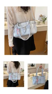 Light blue patent leather shoulder bag for women, stylish tote with metal buckle charms.