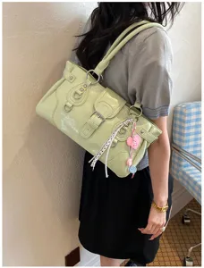Detailed view of the light green retro shoulder handbag with metal buckle and cute charm.