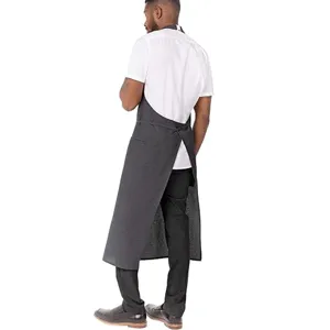 Dark grey professional kitchen apron with cross-back straps, ideal for restaurants and cafes.