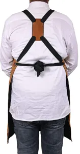 Cross-back work apron detail showing adjustable straps and durable brown leather.