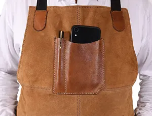 Detail shot of brown PU leather work apron chest pocket with phone and pen for BBQ baking.