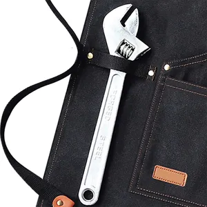 Heavy duty canvas work apron detail featuring multiple utility pockets, metal rivets.
