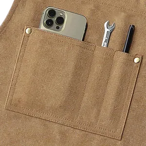 Close up detail view of the heavy canvas work apron pocket showcasing practical tool storage design.