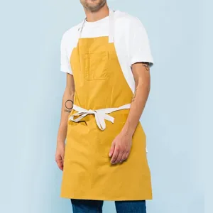 Delantal de trabajo de lona con bolsillos y tirantes contrastantes para cocina, café y panadería.