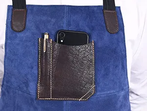 Blue PU leather apron detail shot showing pocket and pen holder for kitchen and BBQ cooking.