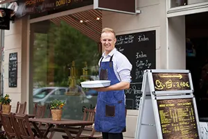 Blue denim work apron with brown PU leather pockets, ideal for baking, cooking and barbecue.