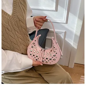 Detailed view of the pink punk style rivet underarm shoulder bag showing metal stud accents.