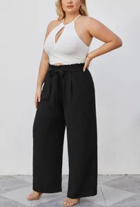 Completo taglie forti da donna con top corto halter bianco e pantaloni larghi neri.