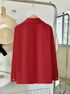 Dettaglio camicia rossa maniche lunghe, vestibilità morbida con bottoni a cuore e stile retro.
