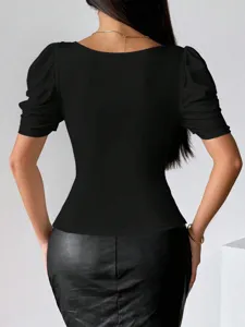 Vista dettagliata del top femminile nero aderente con collo quadrato e maniche a palloncino.