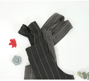 Detailed view of dark grey cotton linen apron with white vertical stripes, kitchen style.