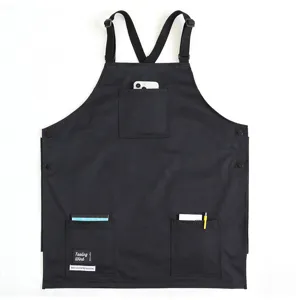 Black work apron with cross straps and multiple pockets, durable and waterproof for cafes.