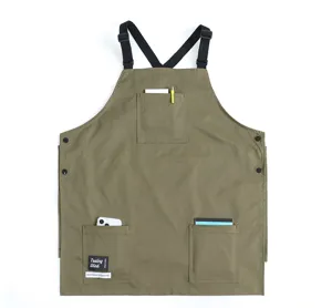 Canvas work apron with cross-back straps and multiple pockets for baristas and cafes.