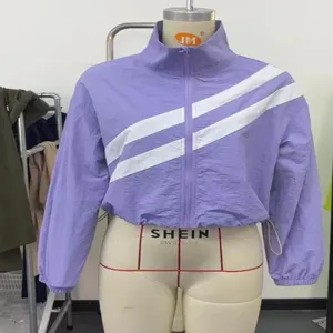 Purple cropped zip-up windbreaker jacket with stylish white diagonal stripes detail view.