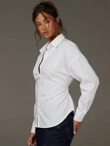 Vista dettagliata della camicia bianca a maniche lunghe con vita aderente e colletto.
