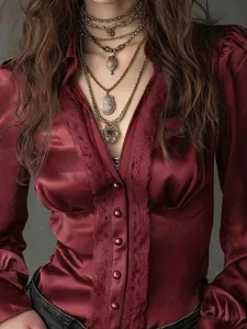 Close-up detail of wine red satin V-neck long sleeve blouse featuring elegant lace trim and buttons.