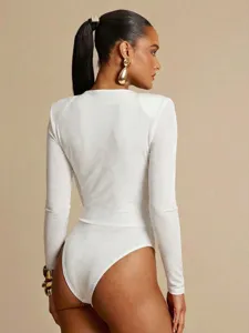 Dettaglio body aderente a maniche lunghe bianco, ideale per stili di moda chic moderni.
