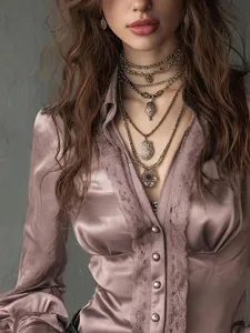 Detail view of women's long sleeve satin lace V-neck blouse with button front design.