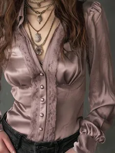 Detail view of a vintage satin long sleeve blouse featuring a deep V-neck and delicate lace trim.