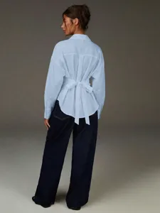 Vista dettagliata della camicia oversize azzurro chiaro con elegante design con fiocco.