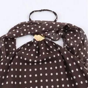 Close-up detail view of brown white polka dot halter sleeveless top with stylish gold ring.