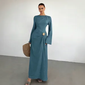 Κομψό γυναικείο μακρύ φόρεμα με μακριά μανίκια, στρογγυλή λαιμόκοψη και μεταλλική αγκράφα.
