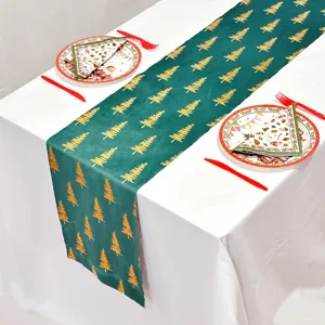 Detalle de camino de mesa verde con patrón de árbol de navidad para decoración festiva.