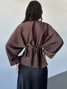Back view of a stylish brown satin long sleeve blouse with a waist tie detail for women.