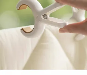 Detalle de pinza grande antiviento para edredón de plástico resistente con almohadillas antideslizantes.
