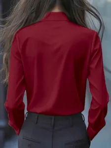 Vista trasera detallada de una blusa roja de manga larga, corte elegante y tela fina.