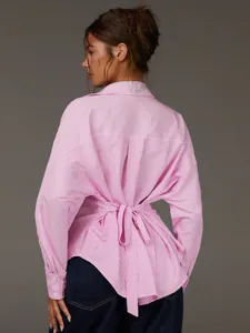 Dettaglio posteriore della camicia donna a righe rosa bianco manica lunga con cintura in vita.