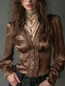 Close-up detail of the elegant brown satin long-sleeve blouse with intricate lace trim.