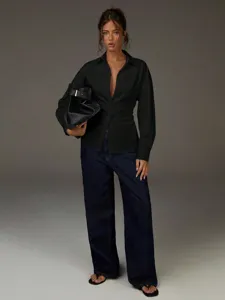 Vista di dettaglio camicia nera donna manica lunga scollo V con design elegante in vita.