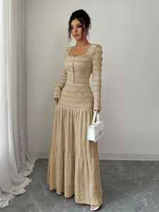 Detailed view of the khaki long-sleeve maxi dress with textured fabric and buttons.