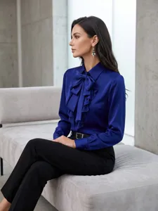 Elegante blusa de satén azul real con elegante cuello de lazo y detalles de volantes.