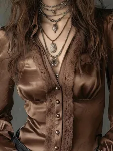 Detail view of solid color deep V-neck long sleeve top with delicate lace and single-breasted buttons.